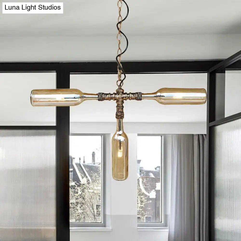 Antique brass-finished chandelier with three amber glass wine bottles in a cross pattern in aged silver black finish