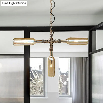 Antique brass-finished chandelier with three amber glass wine bottles in a cross pattern in aged silver black finish