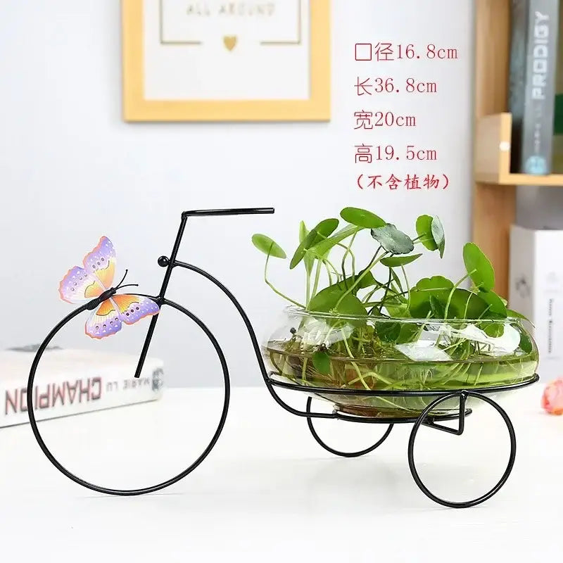 DecorBites™ flamingo metal vase home decor with black metal bicycle planter and glass bowl holding green aquatic plants