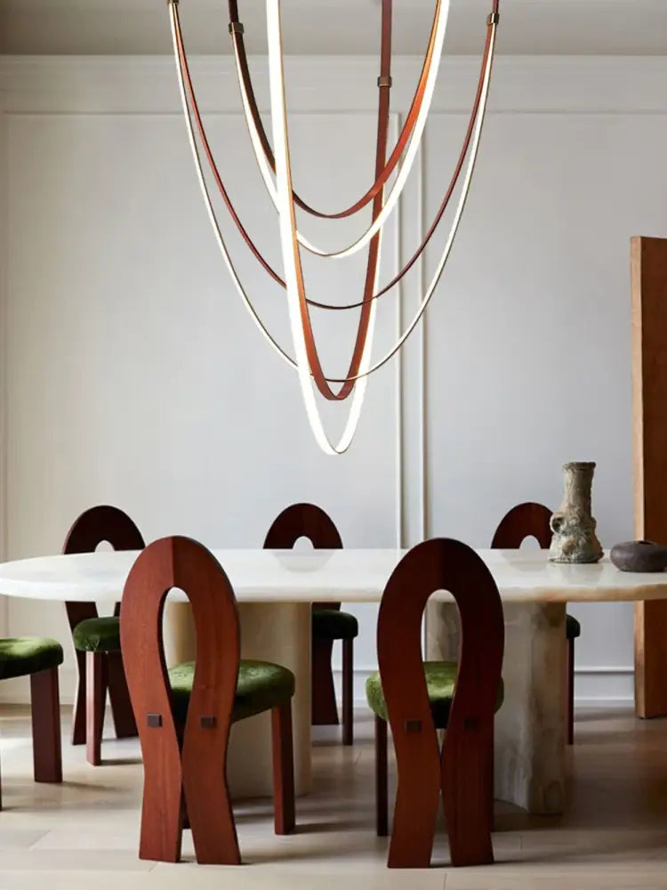A modern flexible leather belt led chandelier with layered curved brown and cream leather straps for living room use