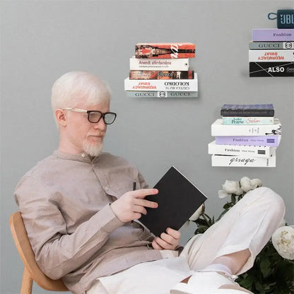 A man with white hair and glasses reads a book while sitting near beige 2pcs floating metal bookshelves by decorbites