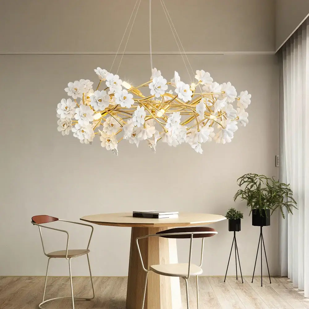 DecorBites™ floral french white ceramic chandelier with delicate white flowers and golden branches above dining table