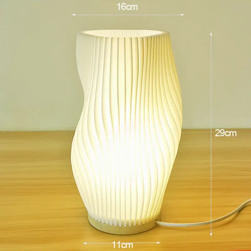 A softly glowing french cream style desk lamp with a curved pleated design ideal for bedroom or study use