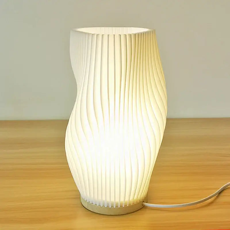 A modern french cream style desk lamp with a softly glowing ribbed design perfect for bedside or study use