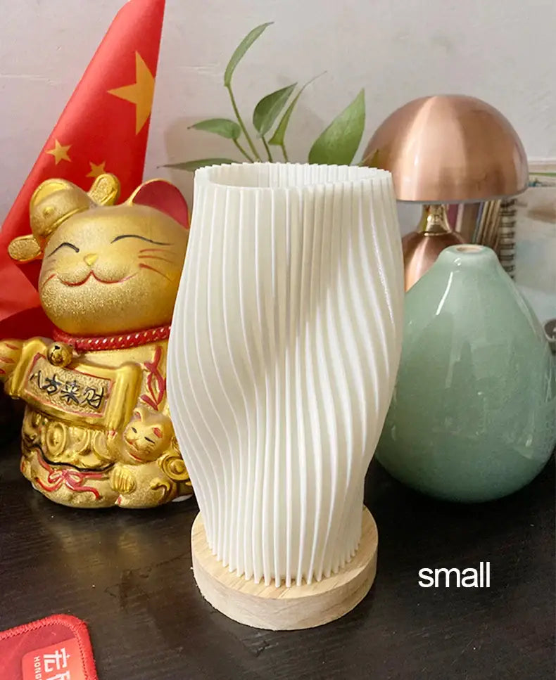 White vertically ribbed ceramic vase with wooden base complementing french cream style desk lamp for elegant decor