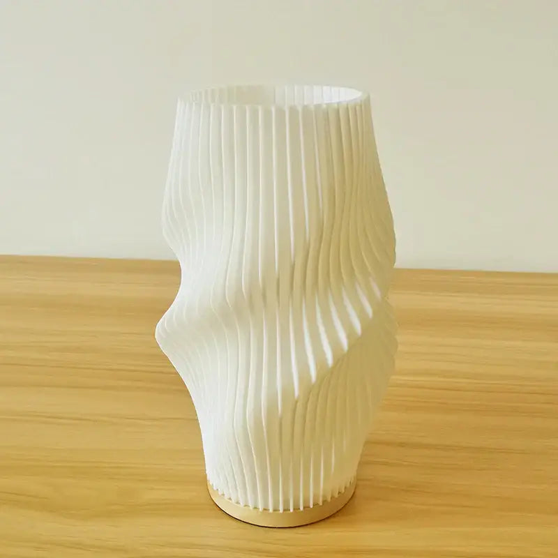 A french cream style white ribbed ceramic desk lamp with an organic form and light wood base for bedside use
