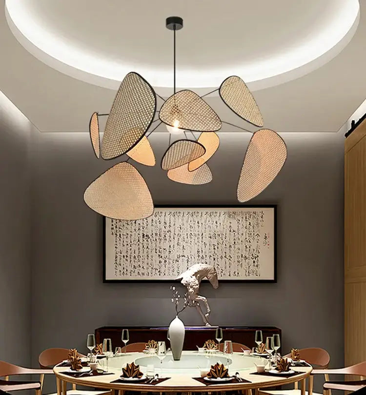 Modern beige-toned rattan chandelier with asymmetrical leaf shades and black rod for french design market lighting by decorbites