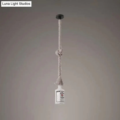 A frosted white glass island lamp shaped like a black wine bottle pendant light hanging from a beige knotted rope