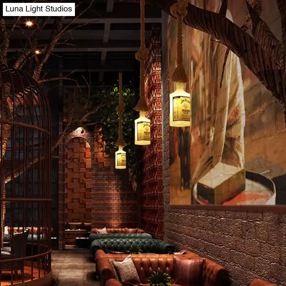Warmly glowing frosted white glass hanging lamps shaped like black wine bottles with thick rope suspension for restaurants