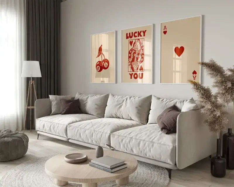 Light gray upholstered sectional sofa with dark brown throw pillows beside DecorBites™ funky queen of hearts wall art set