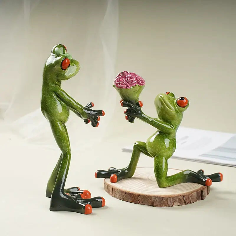 Green ceramic frog figurine with red eyes and orange toes kneeling on wooden slice offering pink rose bouquet decorbites funny frog couple resin decor
