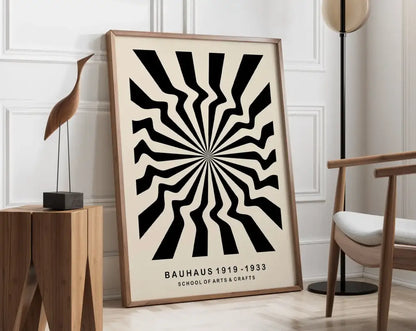 A framed DecorBites™ geometric bauhaus canvas poster with bold black and cream radial stripes in a light wood frame