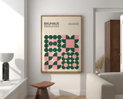 A framed decorbites™ geometric bauhaus canvas print with green and pink design on off white wall art in light wood frame
