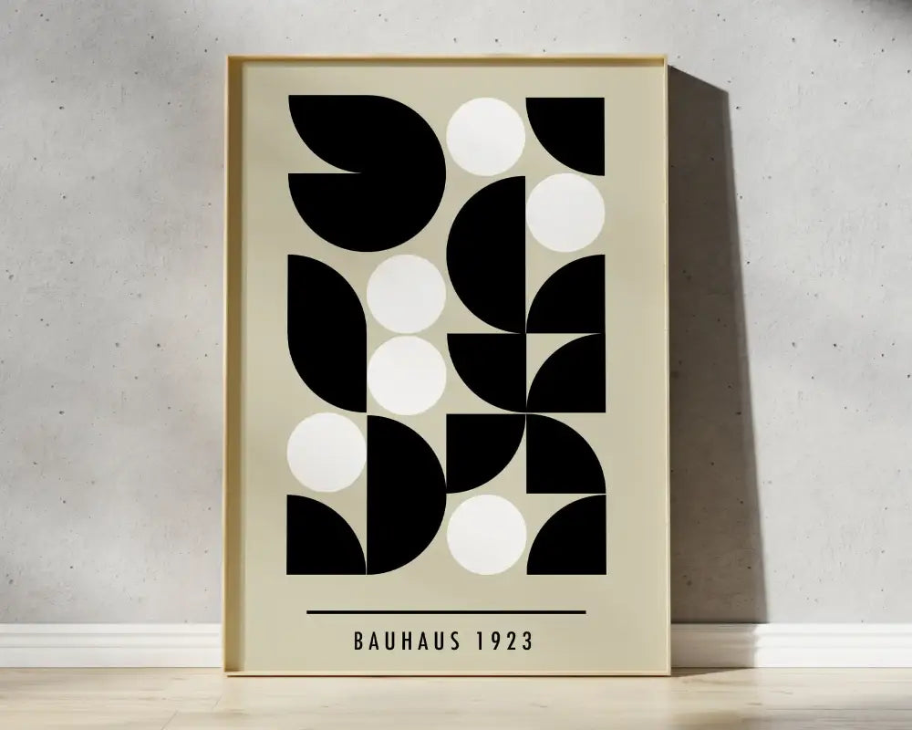 Minimalist bauhaus canvas prints with bold black and white geometric shapes in a light wood frame for modern decor