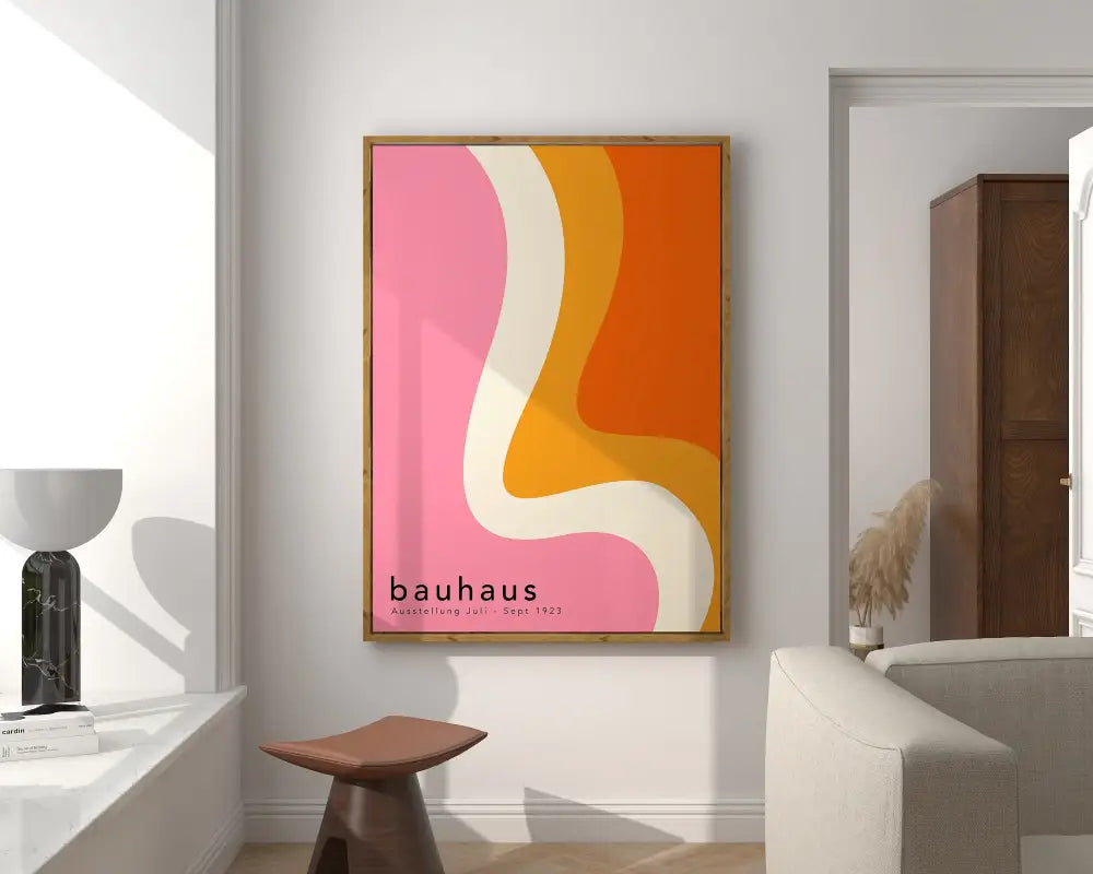 A framed geometric canvas poster with bold pink orange and cream abstract waves and black text in Bauhaus style
