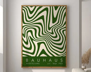 A framed DecorBites™ geometric canvas wall art featuring bold green and cream wavy lines in a light wood frame