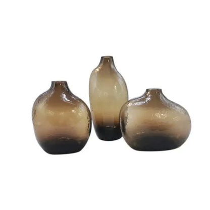 Set of three amber-tinted geometric zen glass vases with textured surfaces for single flower arrangement