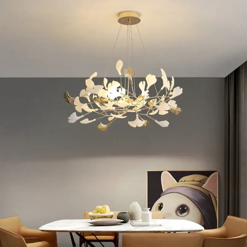 A modern gold-toned decorbites ginkgo leaf chandelier with delicate white and metallic leaf arms for elegant interiors