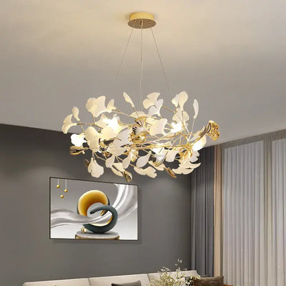 Gold-toned decorbites ginkgo leaf chandelier with delicate white glass leaves and modern branching design for living room