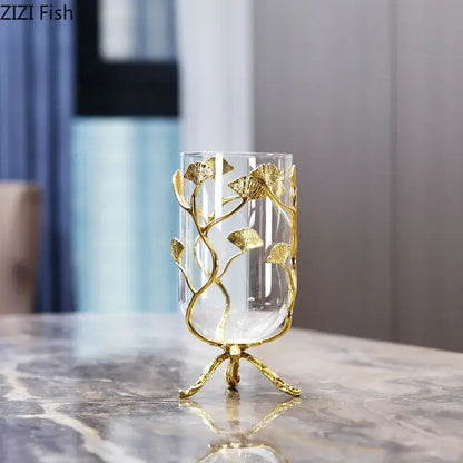 Clear glass vase with intricate gold ginkgo leaf metal detailing on a three-legged golden base from DecorBites Ginkgo Leaf