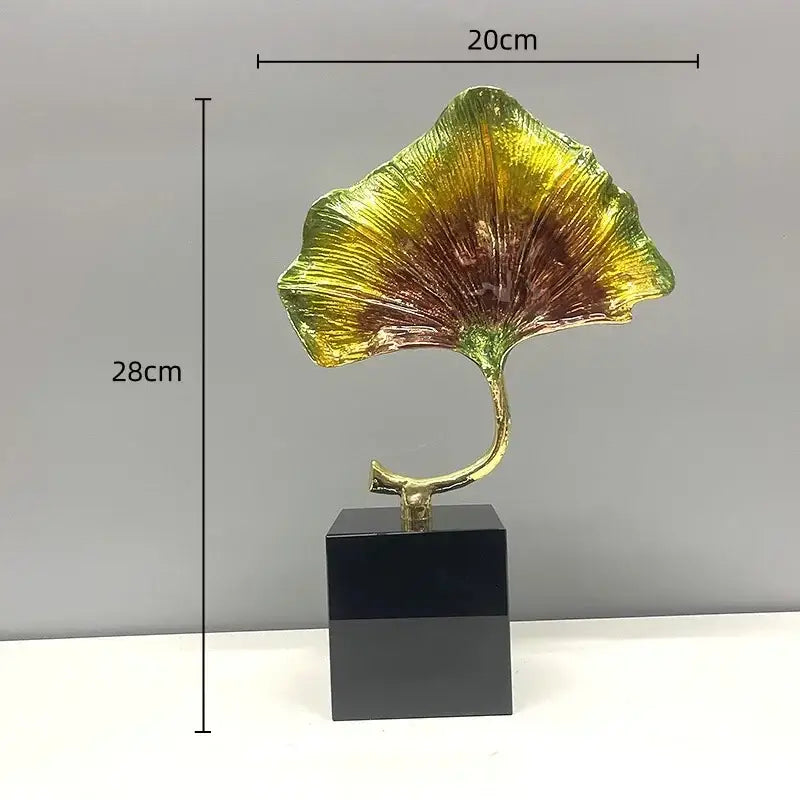 DecorBites ginkgo leaf metal sculpture featuring a glossy gold and green leaf mounted on a black base for home decor