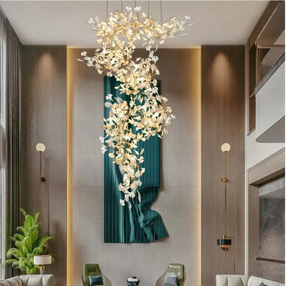 A modern decorbites ginkgo leaf pendant chandelier with white and gold floral elements in a cascading design