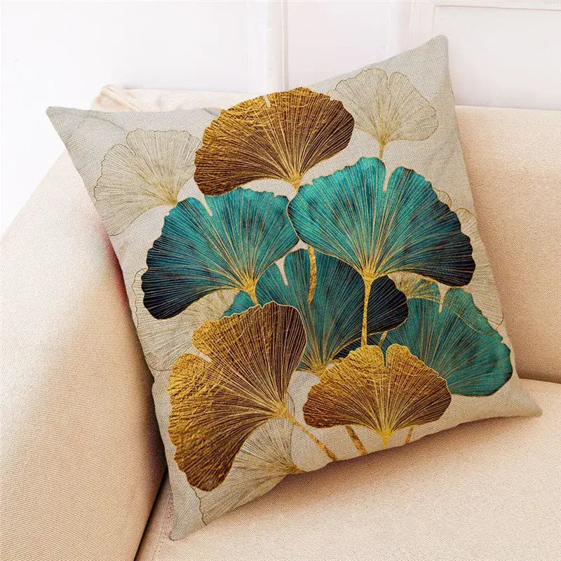 A decorbites ginkgo leaves cushion cover with teal gold and brown embroidery on light beige linen for modern home decor