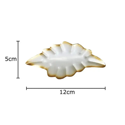 A white ceramic leaf-shaped dish with gold trim from decorbites ginkgo leaves wall decor for living room ornaments
