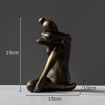 Bronze-colored decorbites girl statue bookends featuring a textured seated hugging figure with gold accents in resin