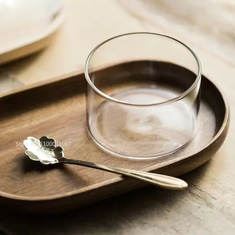 Clear glass cup with smooth rounded rim resting on wooden tray decorbites glass afternoon tea dessert bowl for one