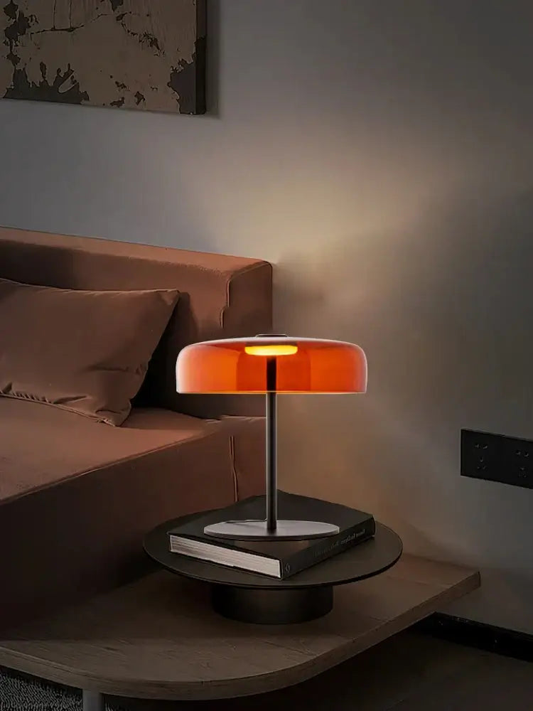 A decorbites glass amber green table lamp with a translucent orange glass shade and slender metallic base for bedroom