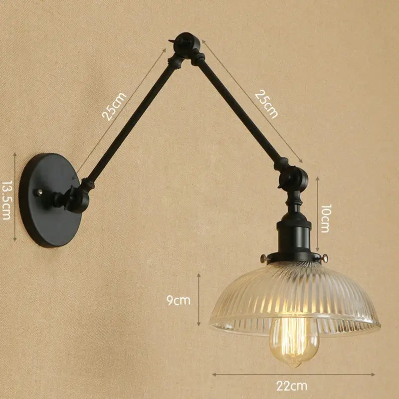 Black wrought iron decorbites glass arm wall lamp with ribbed glass shade and exposed Edison bulb in rustic vintage style