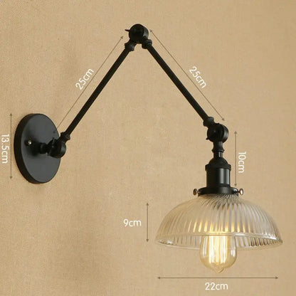 Black wrought iron decorbites glass arm wall lamp with ribbed glass shade and exposed Edison bulb in rustic vintage style
