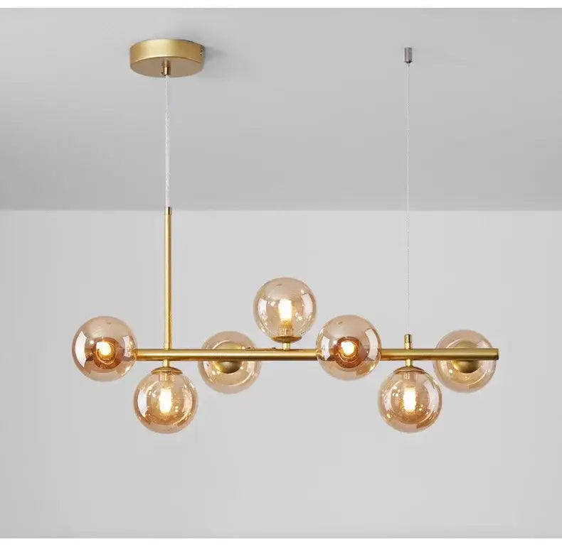 Gold-toned DecorBites™ glass ball ceiling chandelier with seven amber glass globes for dining room lighting
