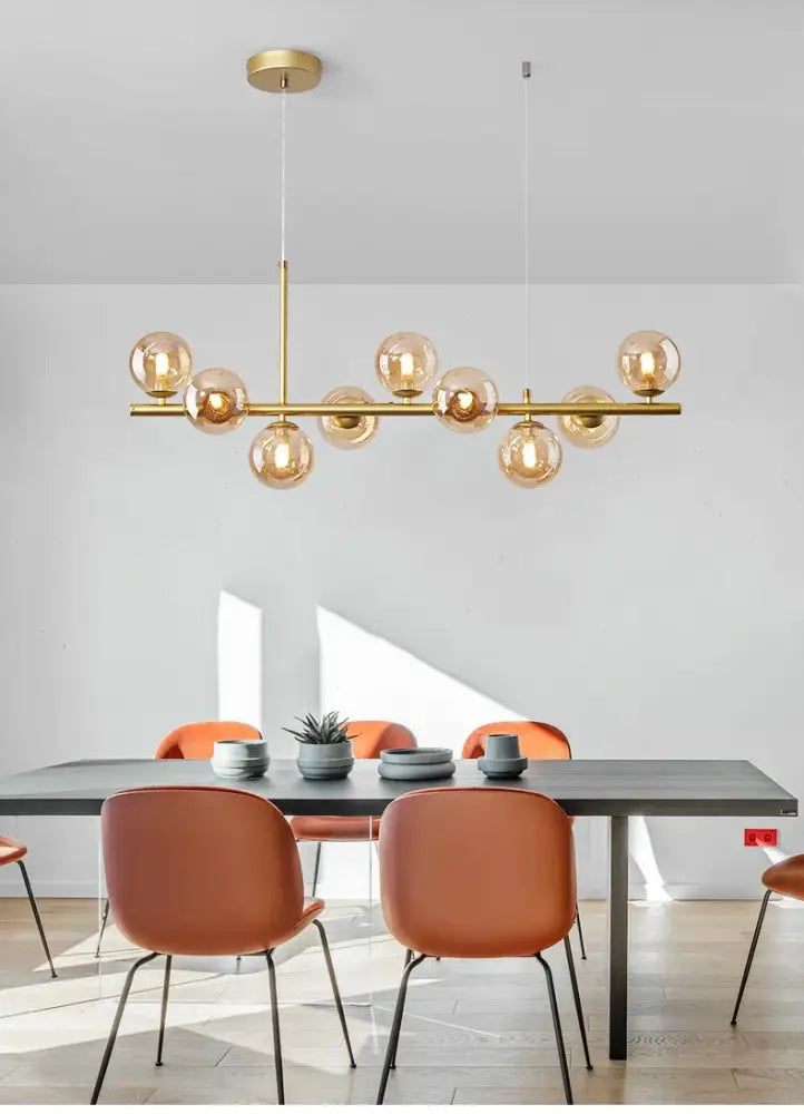 Gold-toned DecorBites™ ball ceiling chandelier with amber glass globes suspended from a central brass rod for home lighting