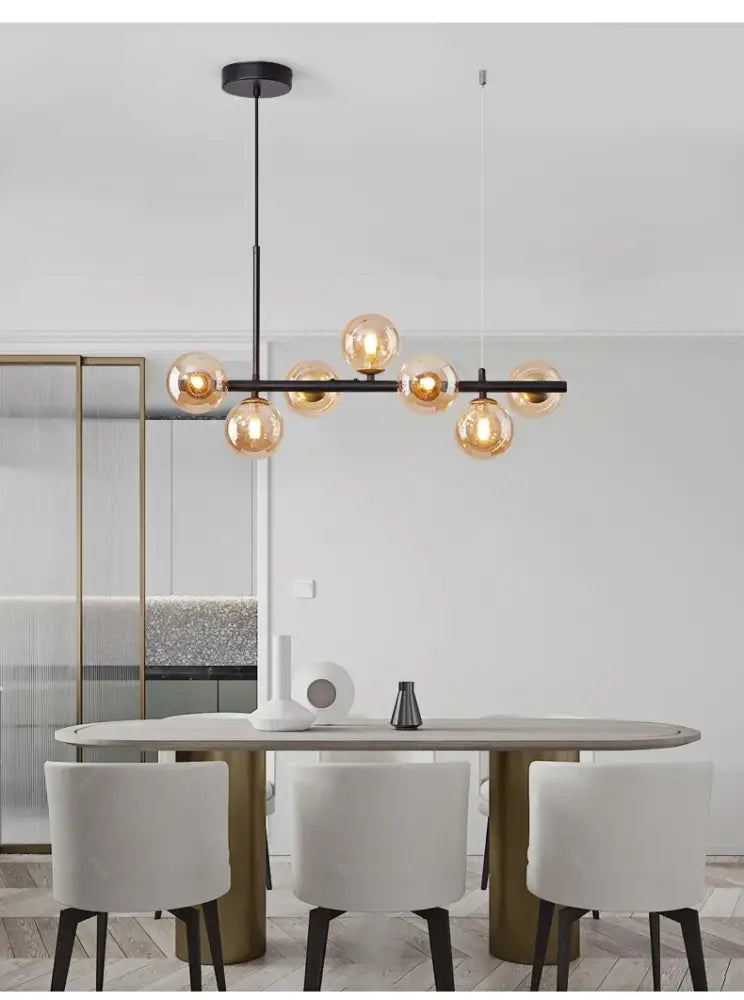 Modern black metal ball ceiling chandelier with warm amber glass globe bulbs by decorbites for home lighting