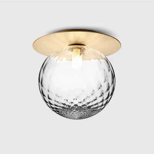 Aisel home ceiling light with decorbites glass ball featuring a hammered clear glass globe and polished brass base