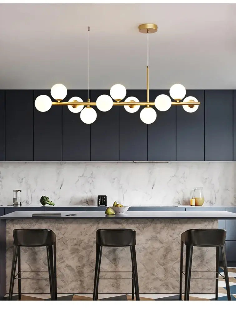 Modern gold-toned DecorBites™ glass ball chandelier with multiple white glass bulbs in a linear dining room design