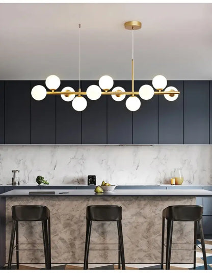 Modern gold-toned DecorBites™ glass ball chandelier with multiple white glass bulbs in a linear dining room design