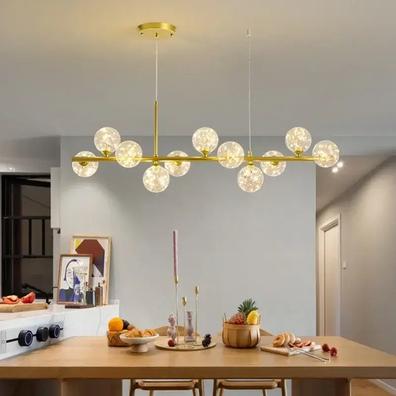 Gold-toned decorbites™ glass ball chandelier with frosted glass globe bulbs in a linear design for home lighting