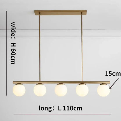 Modern brass-finished pendant light featuring five frosted glass bulbs in a linear decorbites glass ball chandelier design