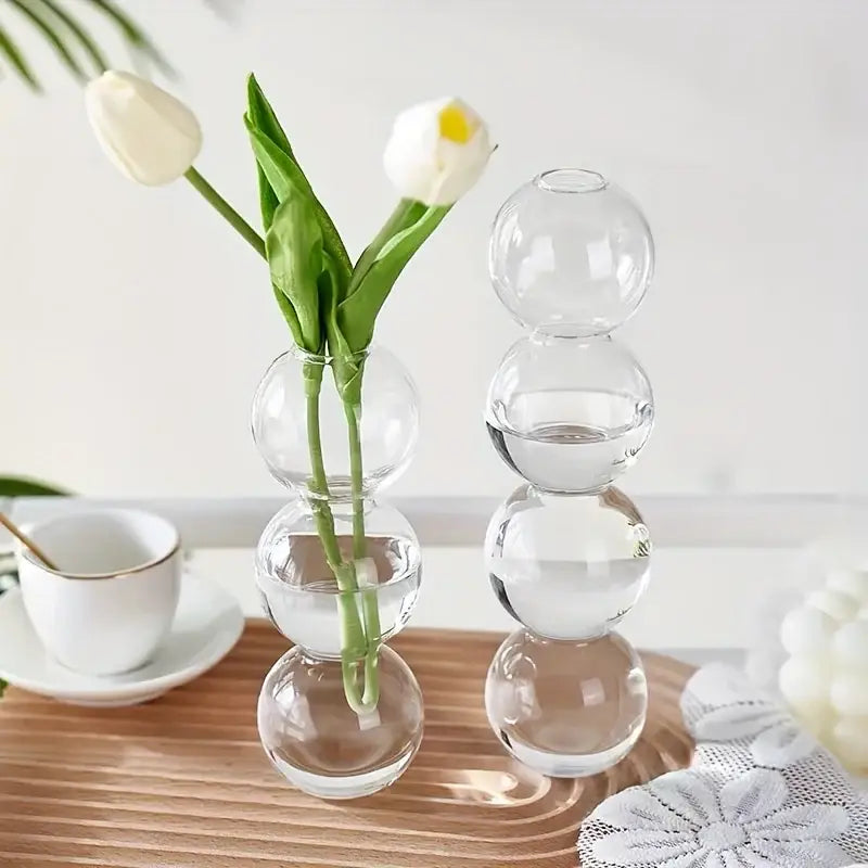 Clear glass bubble hydroponic vase with stacked spherical segments holding white tulips for wedding and home decor