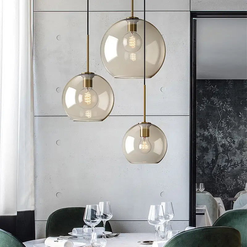 Three spherical glass pendant lights with brass accents and exposed bulbs from decorbites glass pendant lights collection