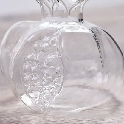 Clear glass pomegranate glass decanter with embossed seed details and molded crown top for home decor and glass vase use