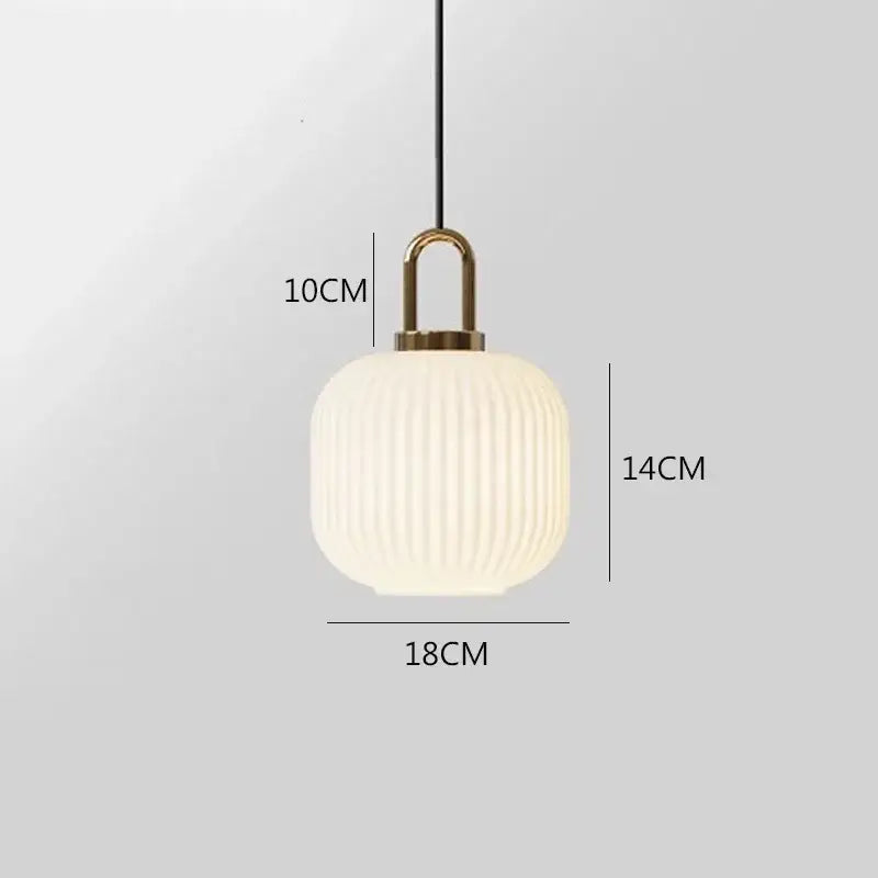 A modern pendant light with a frosted white glass stripe shade and brass fixture by Decorbites for dining rooms
