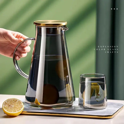 Decorbites glass tea jug with gold lid and handle filled with lemon slices dark liquid in heat resistant water kettle set