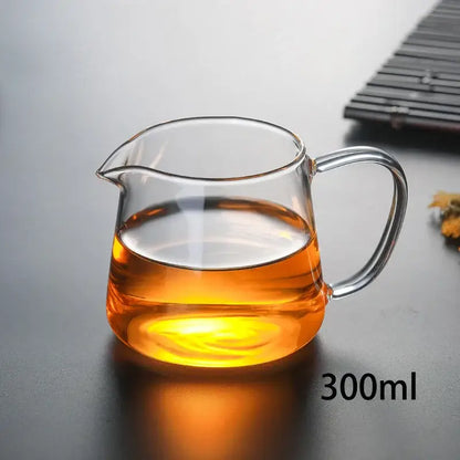 DecorBites glass tea pot set with amber tea in a clear heat-resistant glass pot with curved handle and spout