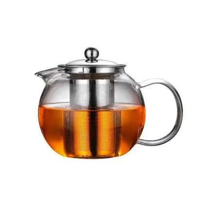 Clear glass teapot with stainless steel lid and built-in filter filled with orange tea decorbites glass teapot
