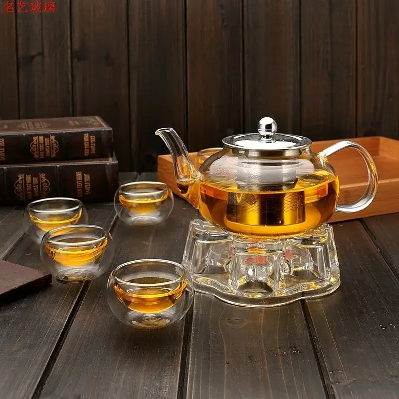 DecorBites glass teapot filled with golden tea featuring a stainless steel lid and handle in a flower tea set