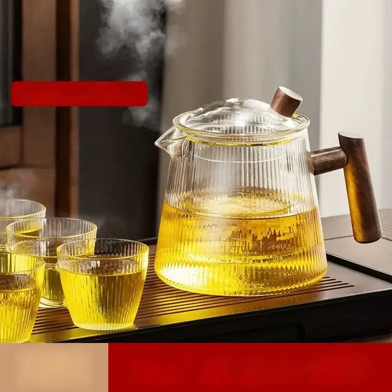 DecorBites glass teapot with vertical ridges wooden handle and lid filled with steaming golden tea in transparent borosilicate glass